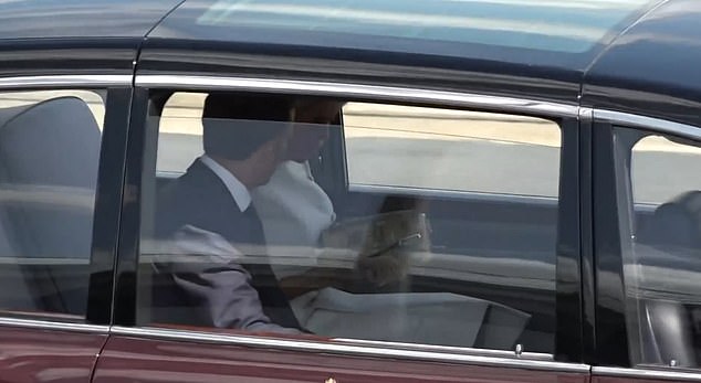 The couple appear to remain frosty in the car as Brigitte Macron looks inside her handbag