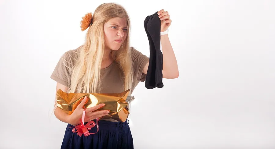 Girl not too happy with her gift which is a pair of socks